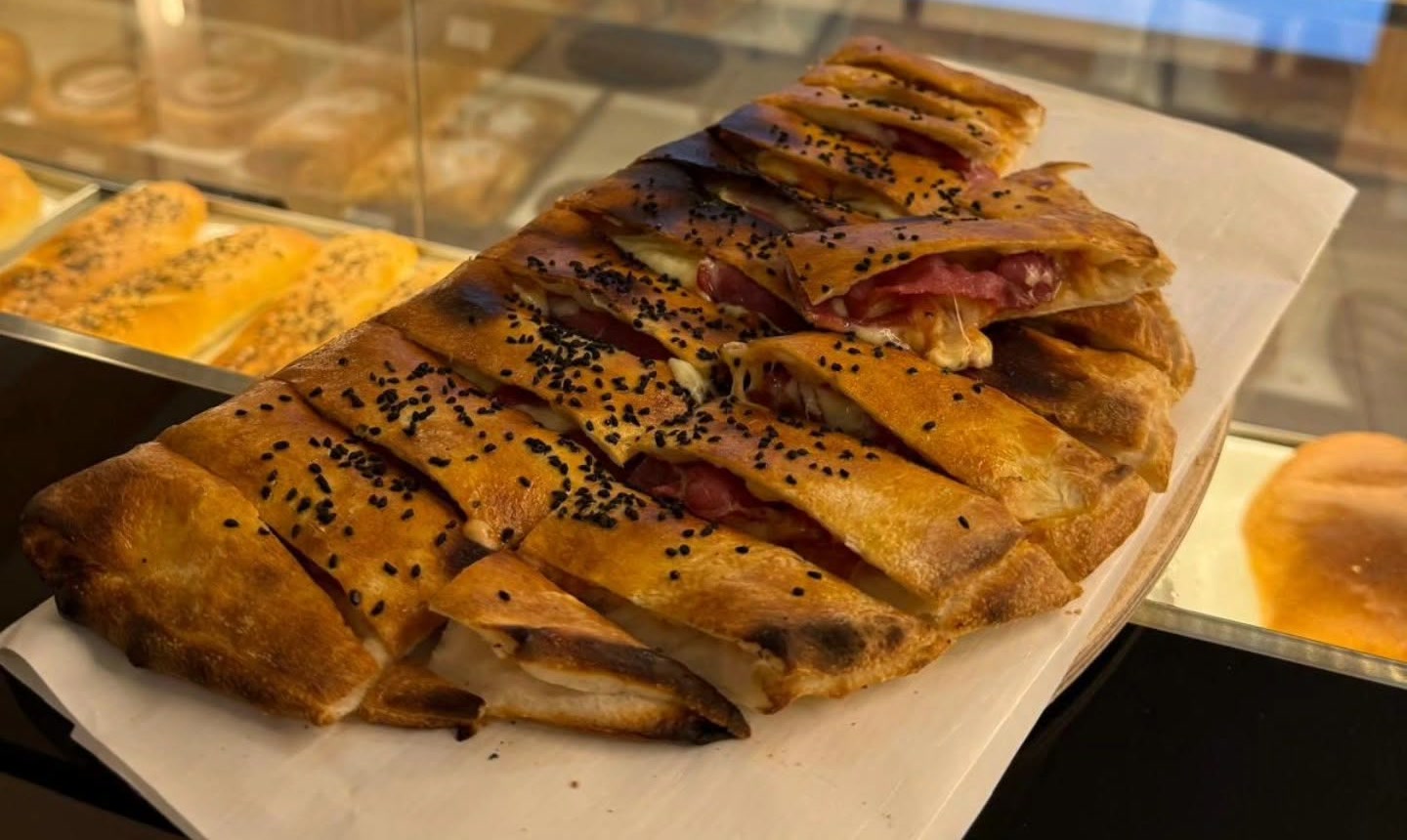 Frisch aufgeschnittenes Samun mit Käse und Prosciutto auf der Theke